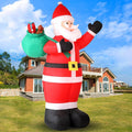 Giant Santa inflatable waving with a green gift sack on a lawn in front of a house