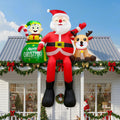 Santa inflatable sitting on a porch roof with an elf and a reindeer beside him