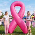Giant pink ribbon inflatable at an outdoor awareness event with two women beside it