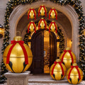Gold jingle bell and red ornament inflatables with red bows stacked around an arched front door