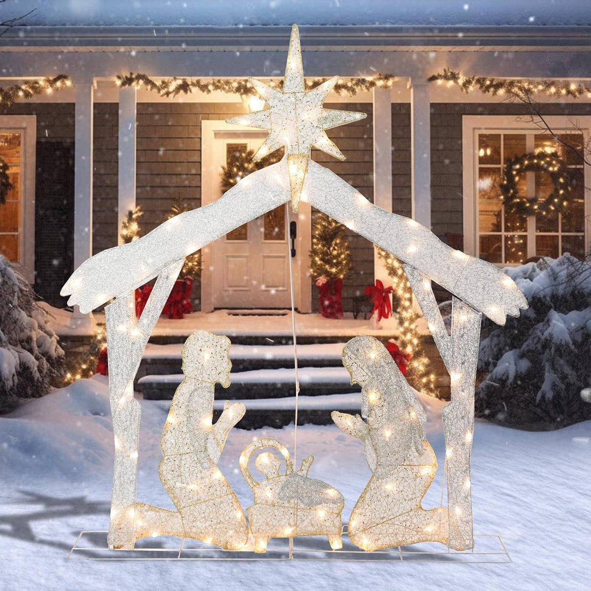 Glittered warm-lit nativity stable with a star and the Holy Family in front of a snowy porch