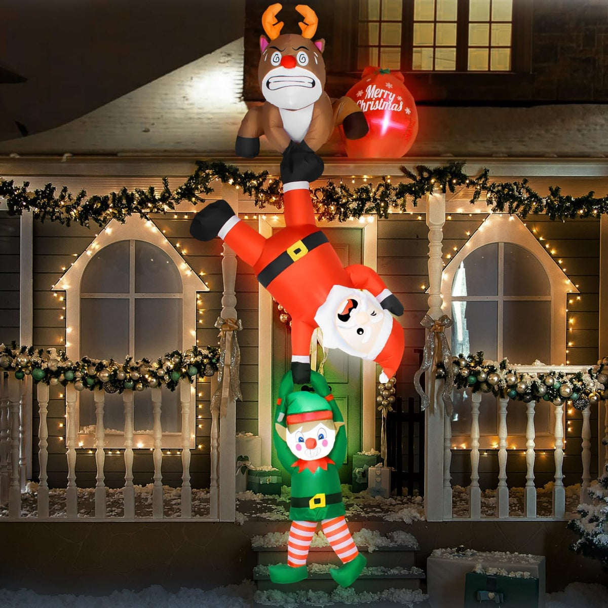 Hanging inflatable of a reindeer, Santa and an elf in a chain down the front of a house