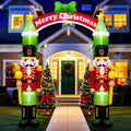 Two nutcracker soldiers holding a red Merry Christmas arch over a front walk at night