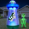Blue UFO inflatable beaming up a cow with a green alien beside it on a lawn at night