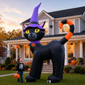 Giant black cat inflatable in a purple witch hat with an orange tail beside a child in front of a house