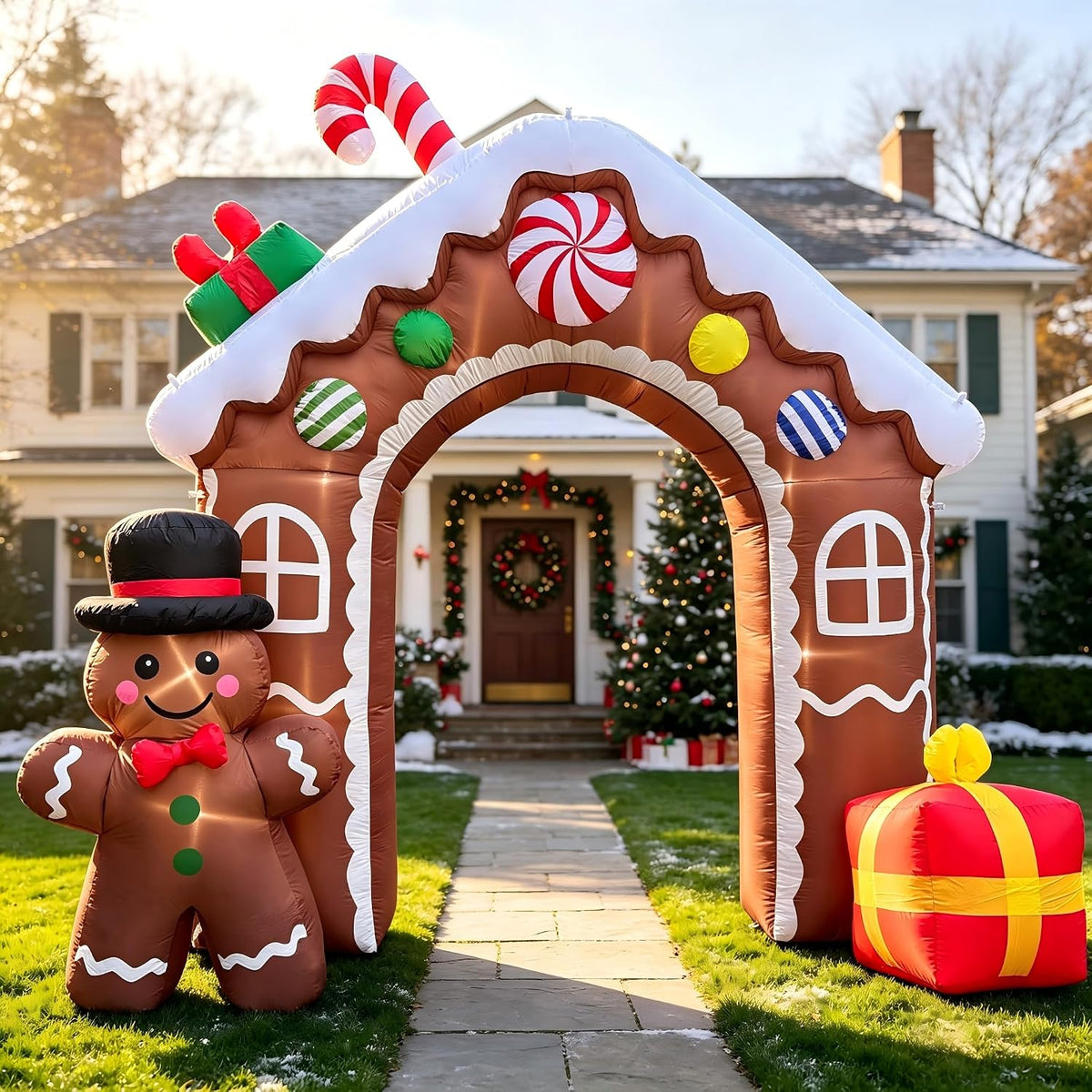 Gingerbread house archway inflatable with a candy cane, a gingerbread man and a gift over a front walk