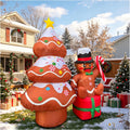 Frosted gingerbread tree inflatable with a gold star beside a gingerbread man in a top hat